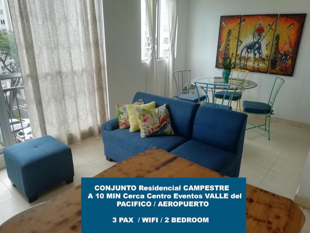 a living room with a blue couch and a table at Conjunto Campestre 10min Centro Eventos Valle del Pacifico, Aeropuerto in Yumbo