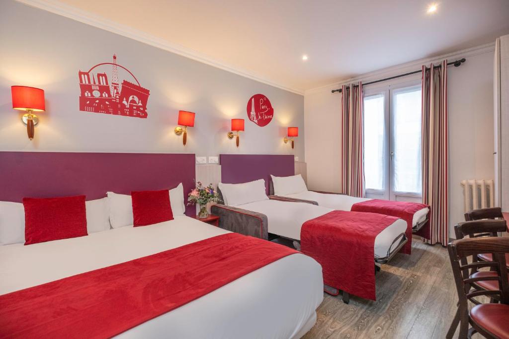 two beds in a hotel room with red and white at Grand Hôtel De Turin in Paris