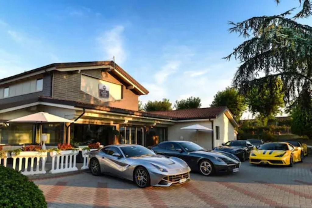grupa samochodów zaparkowanych przed domem w obiekcie Best Western Plus Hotel Modena Resort w mieście Formigine