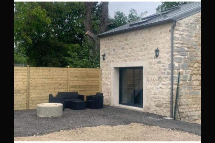 un groupe de chaises bleues devant un bâtiment dans l'établissement HOME BRUNO, à Triel-sur-Seine