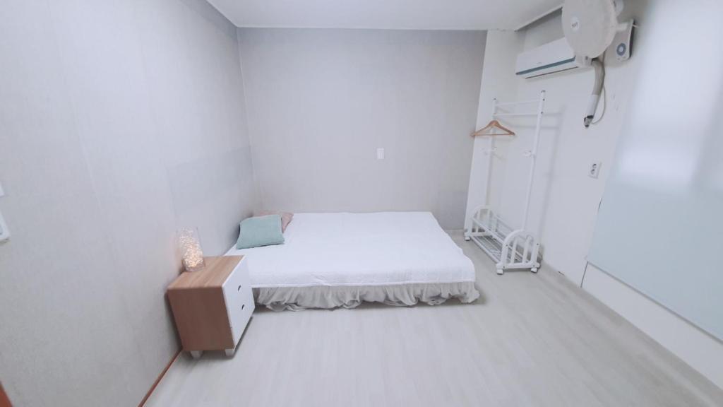 um quarto de hospital com uma cama num quarto branco em Mokhwajang Motel em Goyang