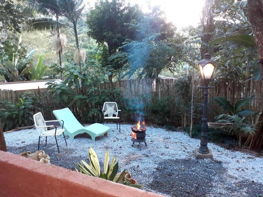 einen Hinterhof mit einer Feuerstelle und Stühlen sowie einem Straßenlicht in der Unterkunft Casa de campo em Embu das Artes in Embu