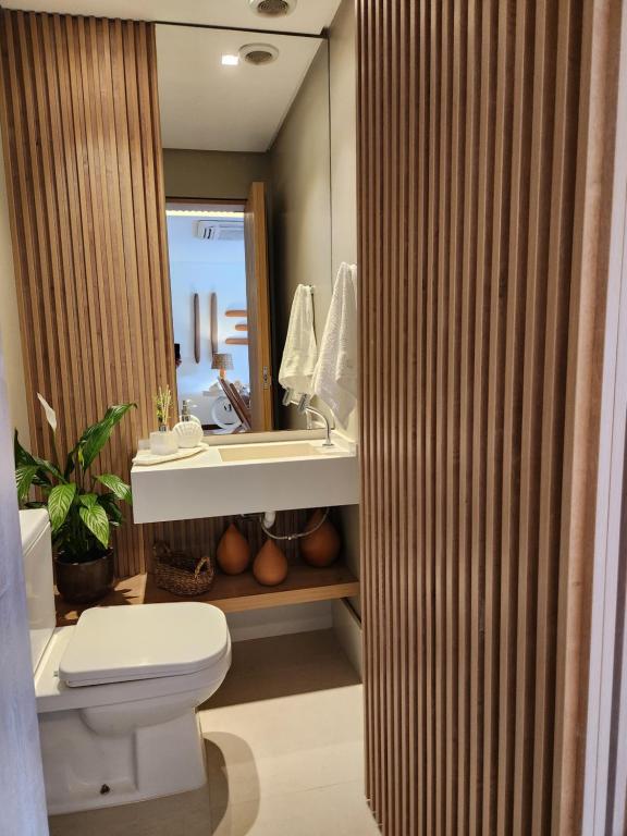 ein Badezimmer mit Toilette, Waschbecken und Spiegel in der Unterkunft Casa Luxo com piscina privativa próximo a Igrejinha - Com colaboradora e enxoval in Praia dos Carneiros