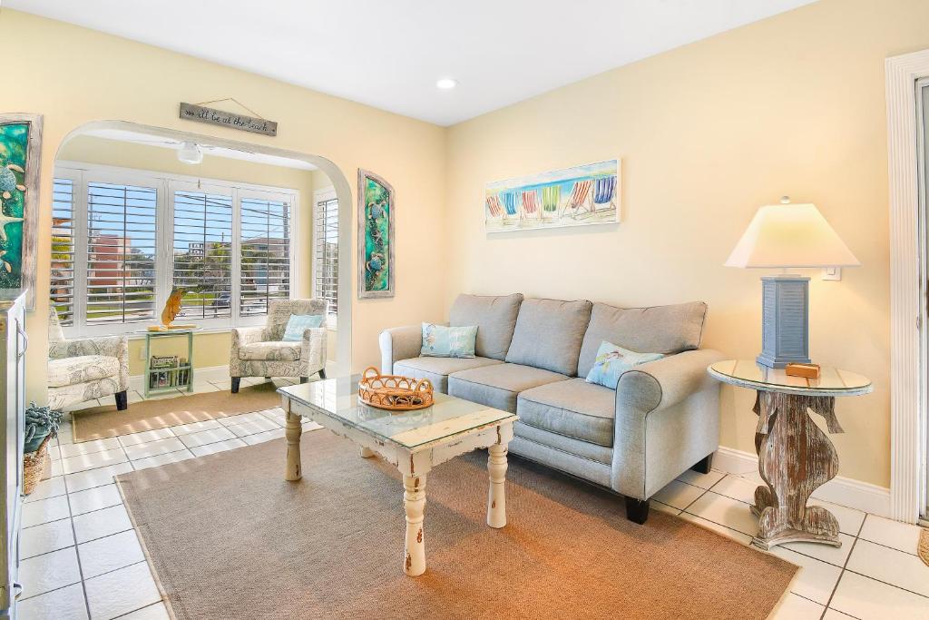 a living room with a couch and a table at Funshine Pointe Capri in St. Pete Beach