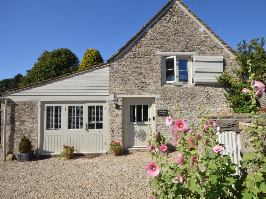 a stone cottage with a garden and flowers at 1 Bed in Bibury 29026 in Quenington