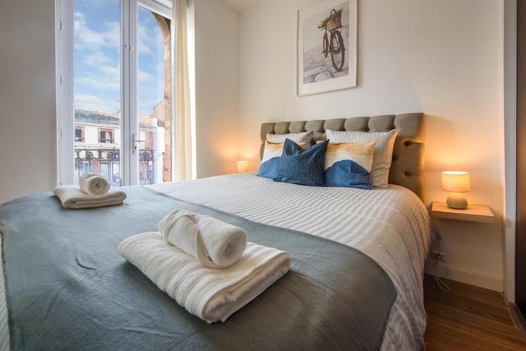 une chambre avec un grand lit avec des serviettes dessus dans l'établissement Cocon des Minimes - Appt pour 3 avec balcon, à Toulouse