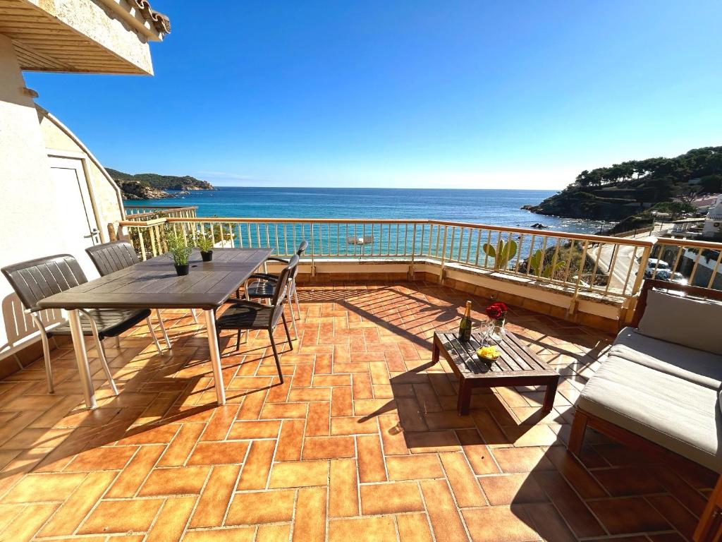 eine Terrasse mit einem Tisch, Stühlen und Meerblick in der Unterkunft Charming apartment in La Fosca Beach in Palamós