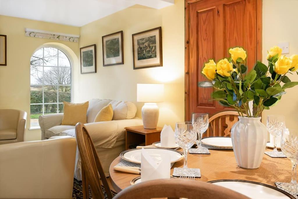 een woonkamer met een tafel met gele bloemen erop bij Woodcutter's Cottage - Peaceful Country Retreat! 