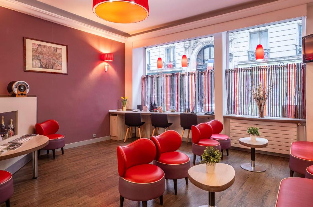 a barber shop with red chairs and tables and windows at Grand Hôtel De Turin in Paris
