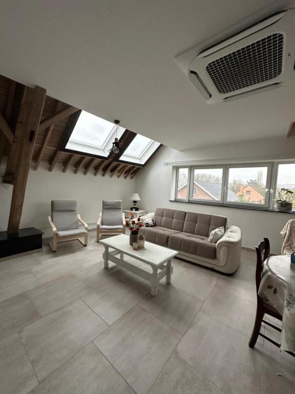 a living room with a couch and a table at Gîte du Fenil in Lobbes