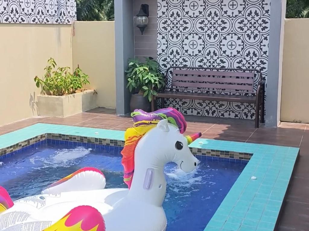 a toy unicorn in a pool next to a bench at Laman Zavilla Dhoma 2 in Bagan Lalang