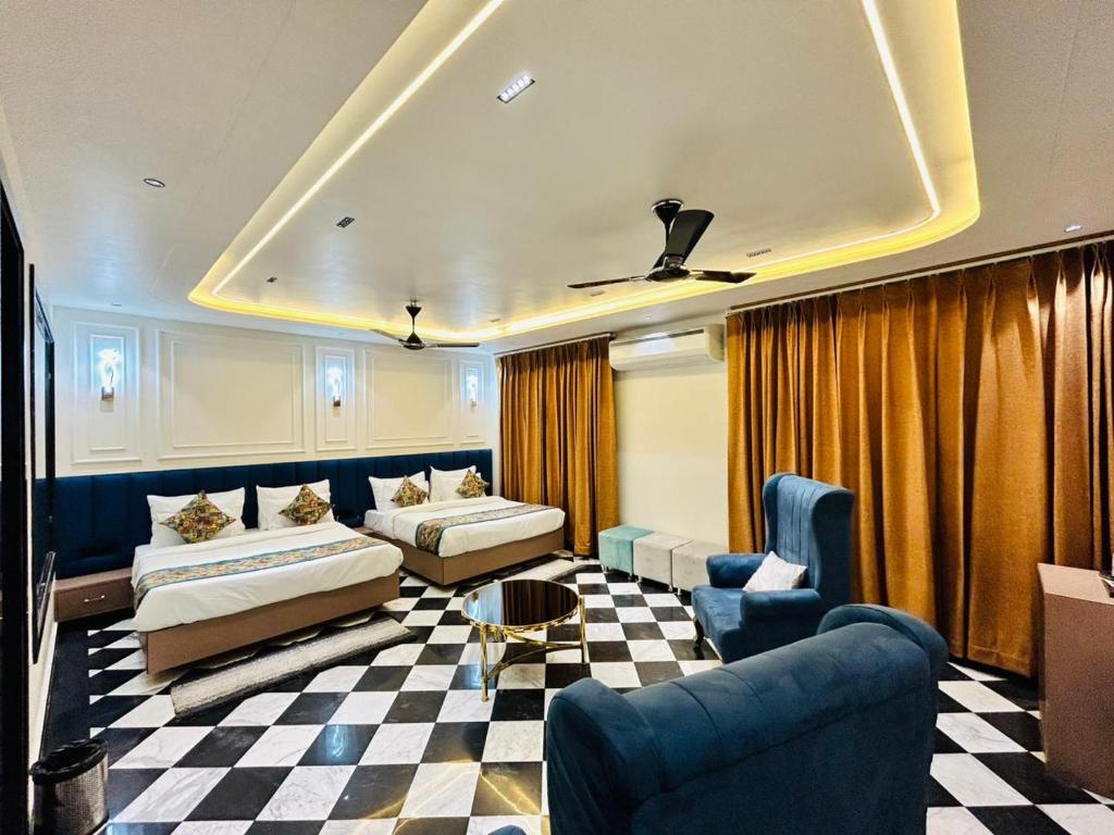 ein Hotelzimmer mit 2 Betten und einem karierten Boden in der Unterkunft Taj Ronak Luxury Hotels in Agra