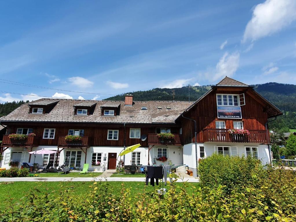 a large wooden house in the middle of a field at Haus Kampl - Appartement Ödensee in Obersdorf