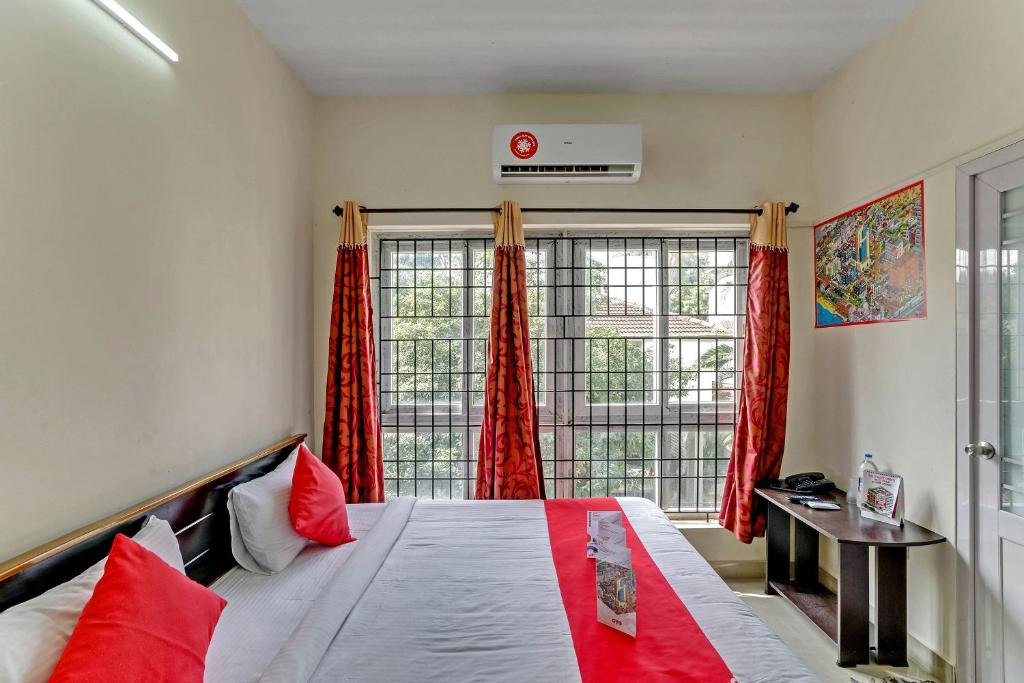 a bedroom with a bed with red pillows and a window at OYO Flagship 15148 Sky Pix Near Kasi Talkies in Chennai