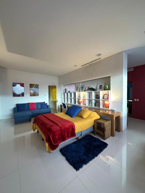 a bedroom with a large bed and a blue couch at Habitación en Casa Estudio Guerrero in Santiago