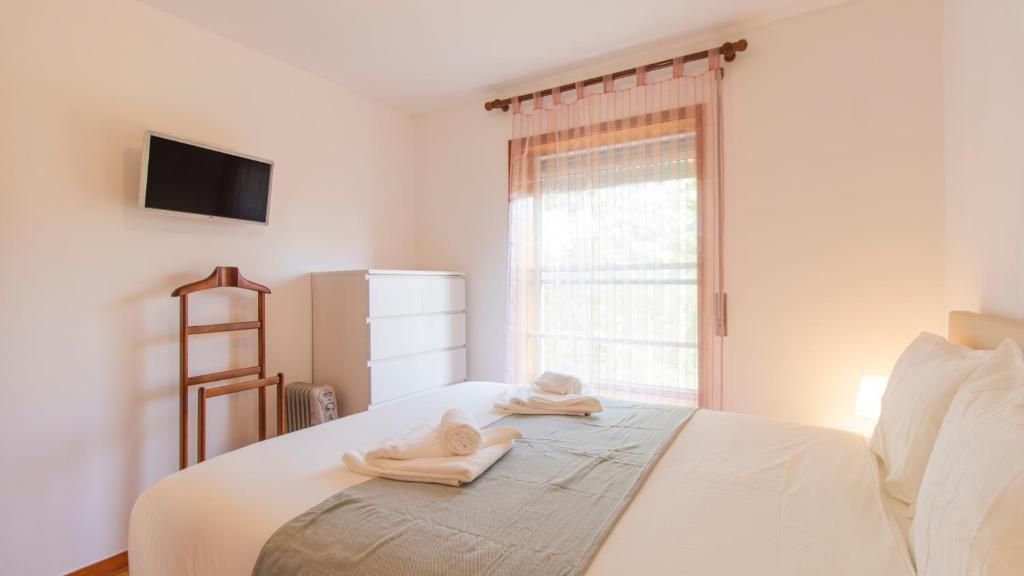una camera da letto con un letto e asciugamani di Fabulous Matosinhos Apartment by Unique Hosts a Senhora da Hora