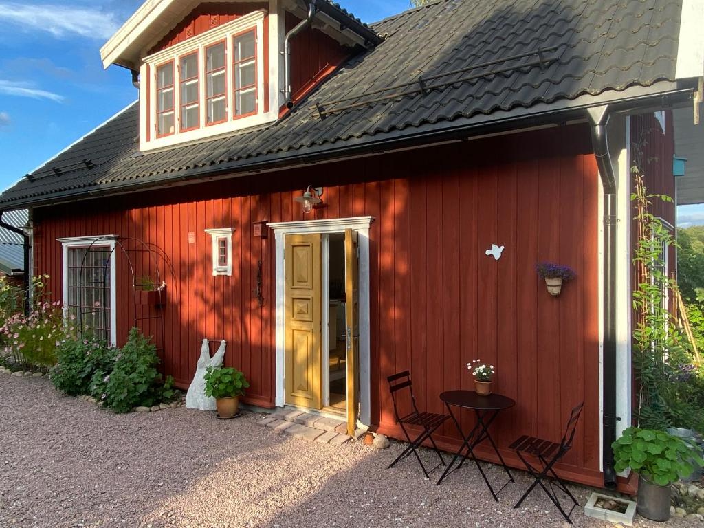 a red barn with chairs and a table in front of it at Röda huset in Hallstahammar