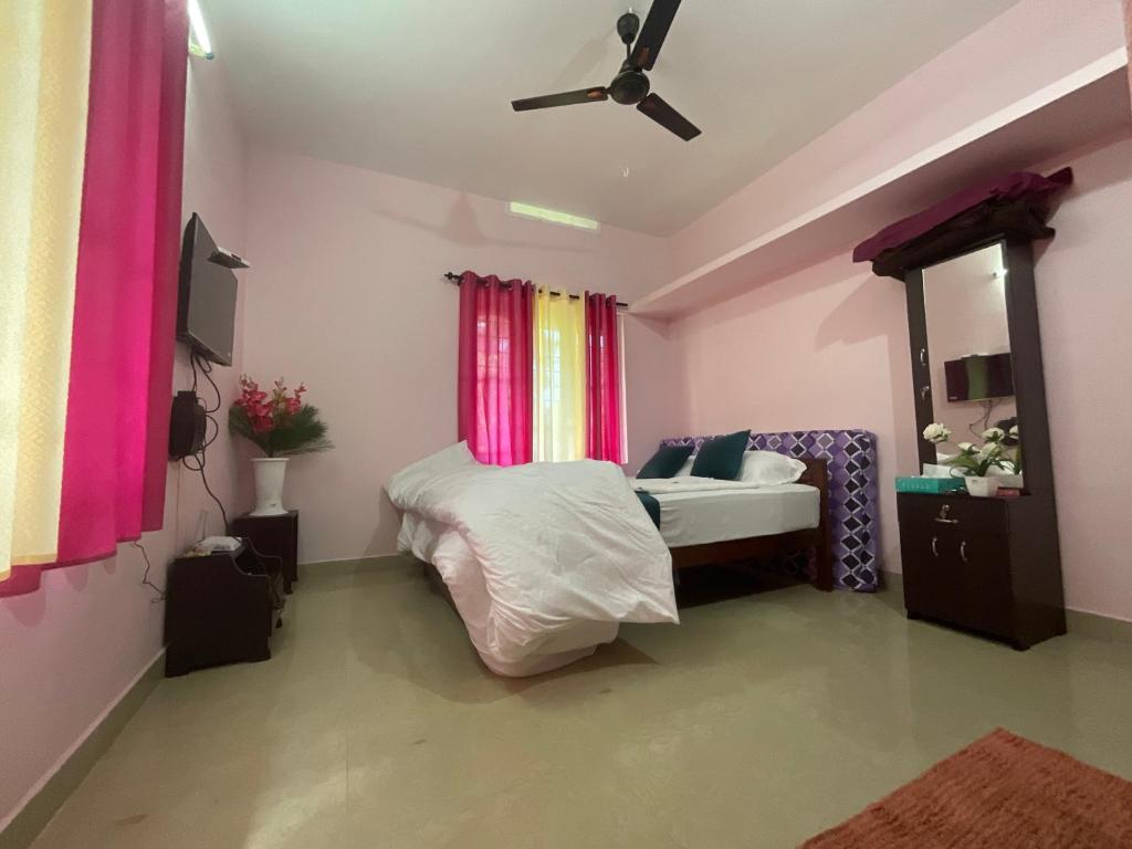 een slaapkamer met een bed en een plafondventilator bij anliyaholidayhome in Anachal
