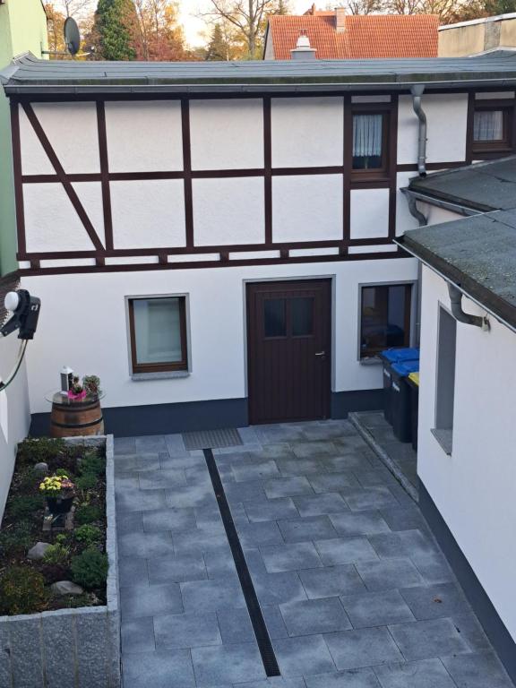 Cette chambre offre une vue antérieure sur une maison blanche dotée d'une terrasse. dans l'établissement Ferienwohnung am Weißgerbermuseum, à Doberlug-Kirchhain