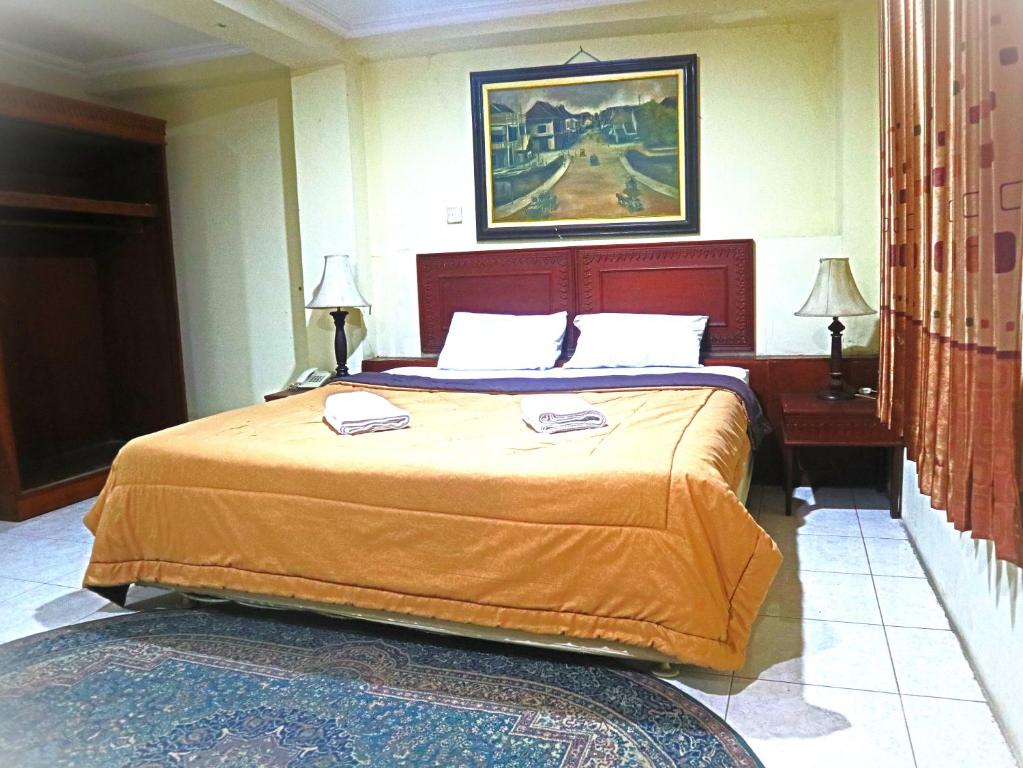um quarto com uma cama grande num quarto em D'Hans Hotel em Surabaya