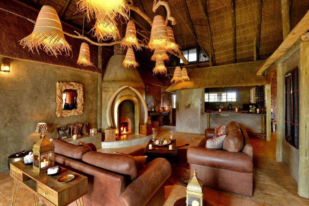 a large living room with leather furniture and a fireplace at Eco-Lodge Gamagara Africa 