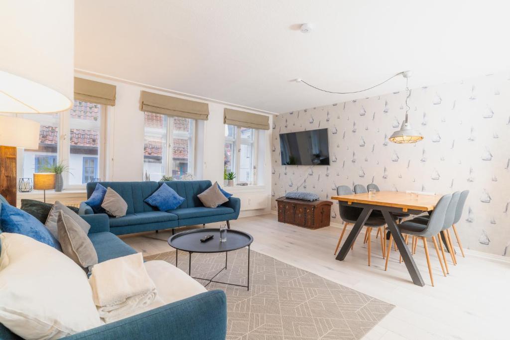 a living room with a blue couch and a table at Admiralskoje direkt am Hafen in Flensburg