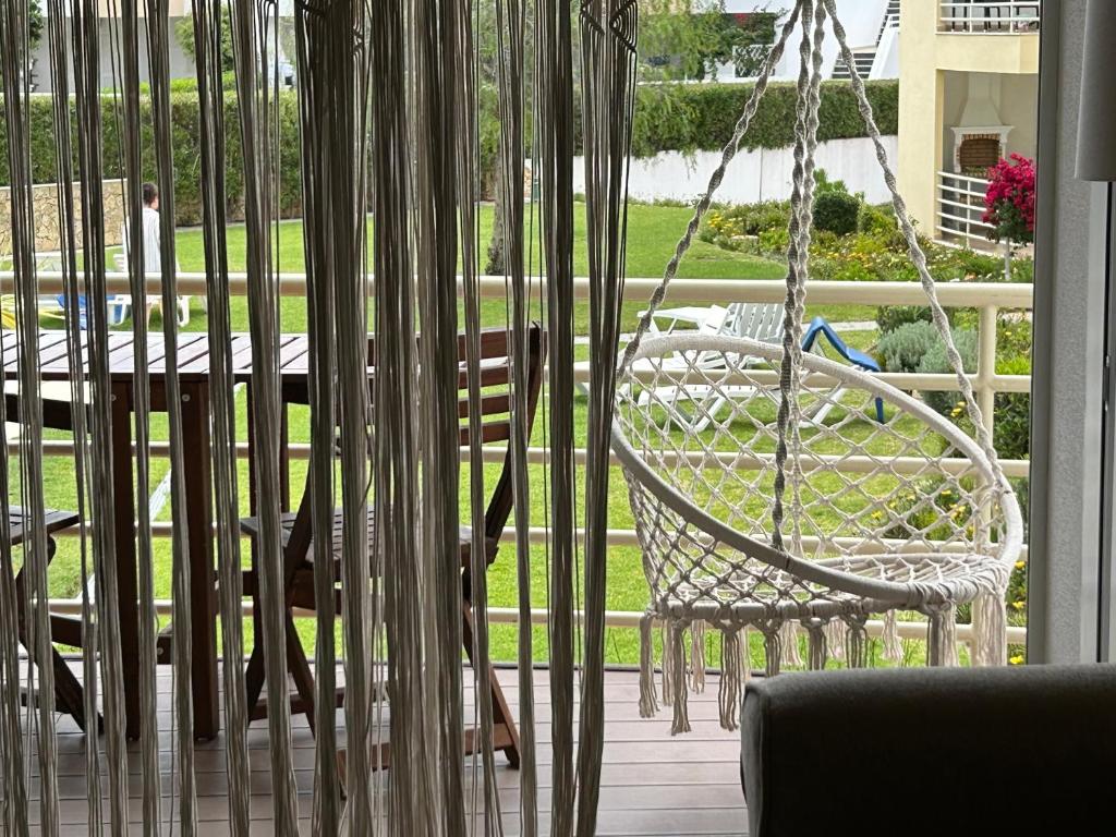 eine Veranda mit einem Schaukelstuhl und einem Tisch in der Unterkunft Dream House in Albufeira