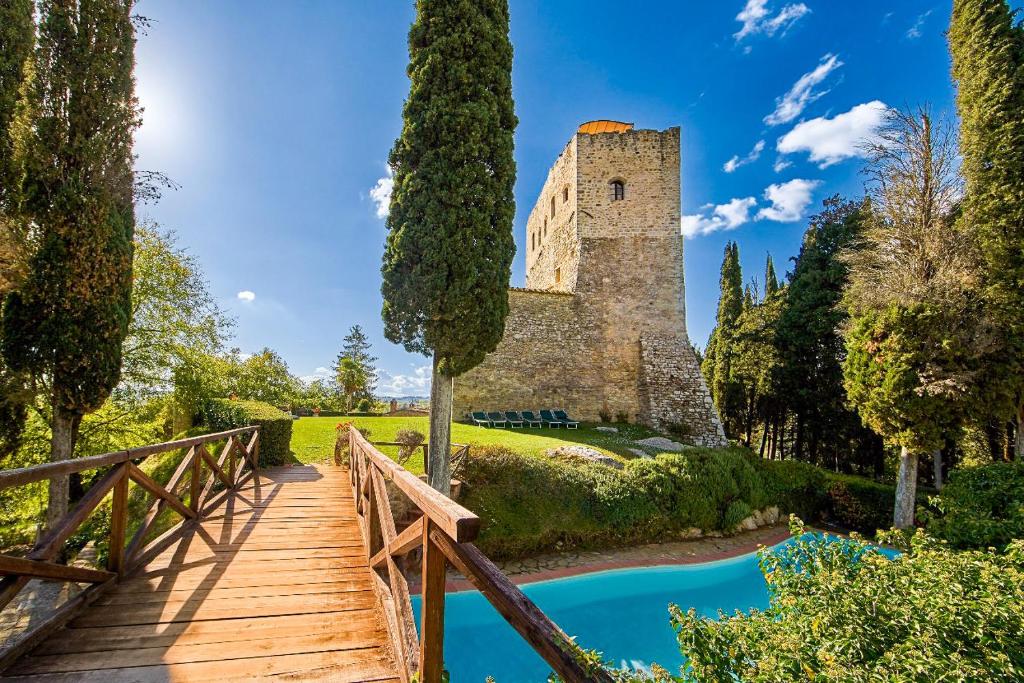 un pont en bois menant à un château avec une tour dans l'établissement Castello Di Tornano Wine Relais, à Gaiole in Chianti