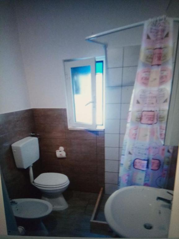 サヴェッレトリにあるappartamenti del pescatoreのバスルーム(トイレ、洗面台付)、窓が備わります。