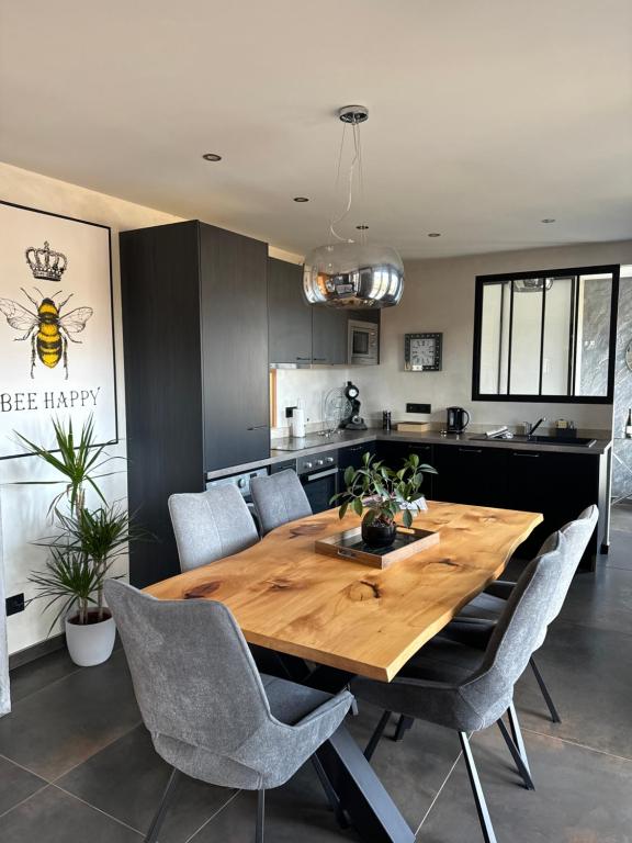 a kitchen and dining room with a wooden table and chairs at La reine appartement pour deux personnes avec magnifique vue et jacuzzi in Gérardmer