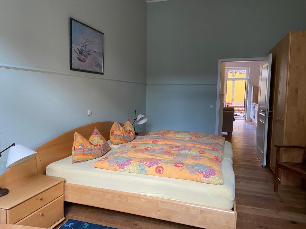 ein Schlafzimmer mit einem großen Bett mit bunter Bettwäsche und Kissen in der Unterkunft FeWo mit 2 Schlafzimmern, Wohnküche, Terrasse in Bonn
