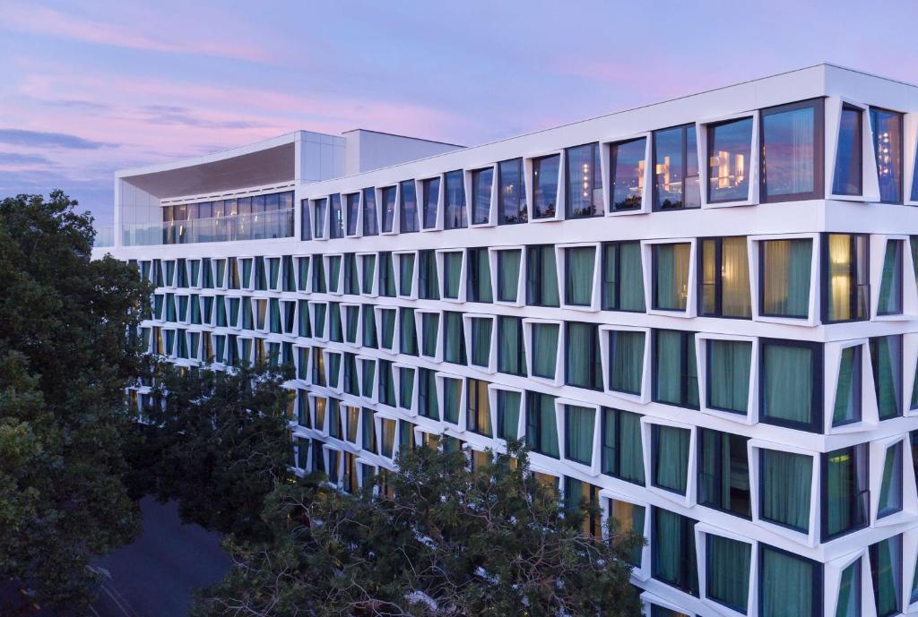 a tall white building with many windows at dusk at ATLANTIC Hotel Münster in Münster