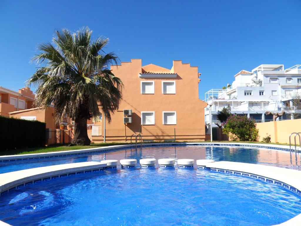 a large swimming pool with stools in front of a building at Adosado MAR DE CORAL en el Vergel in El Verger