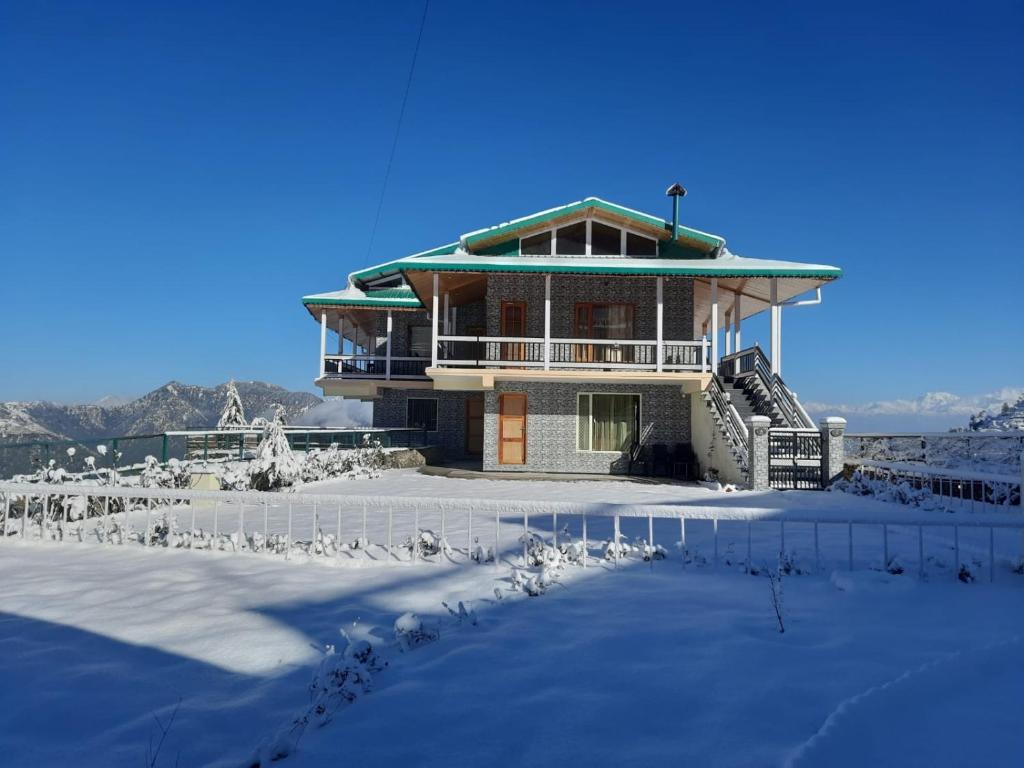 a house in the snow with a lot of snow at HighField Villa in Kanatal