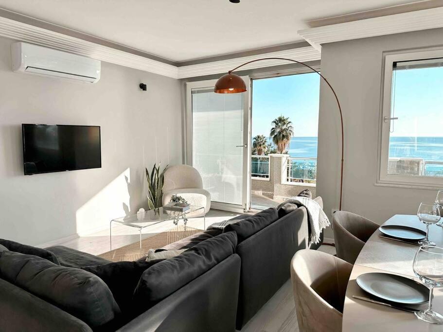 a living room with a large couch and a table at Cleopatra Beach l Truly Unique Sea View in Alanya