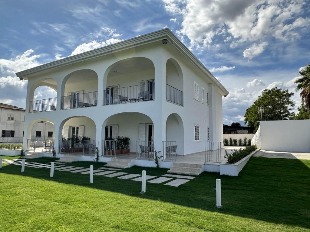um grande edifício branco com um relvado em Villa Achiropita em Rossano