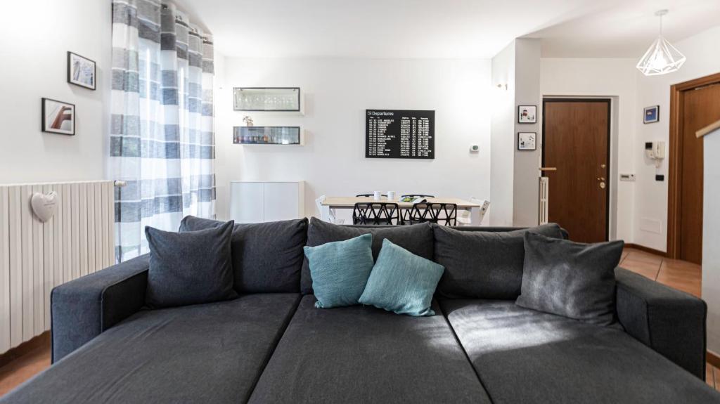 uma sala de estar com um sofá cinzento com almofadas azuis em Italianway - Villa Donatori em Lesmo