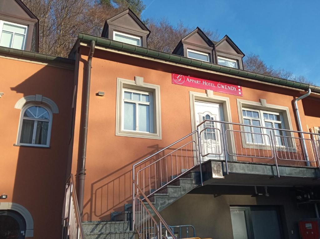 um edifício com uma escada ao lado em Appart-Hotel Gwendy em Bour