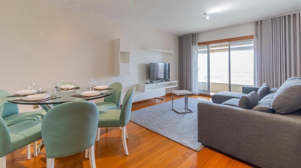 uma sala de estar com uma mesa e um sofá em Magnificent Matosinhos Sul Apartment by Unique Hosts em Matosinhos