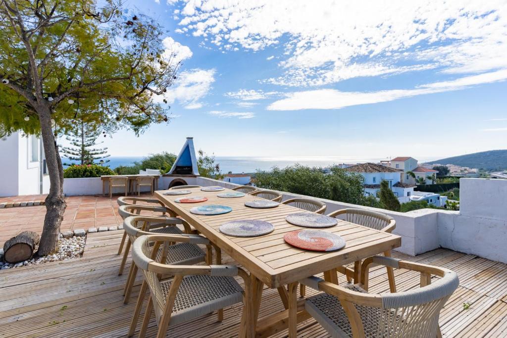 een houten tafel en stoelen op een houten terras bij 2421 Villa Joya de Guadalupe in Manilva