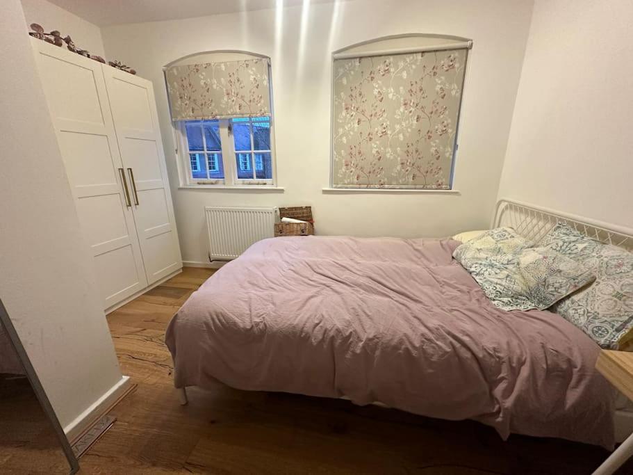 ein Schlafzimmer mit einem Bett und zwei Fenstern in der Unterkunft Beautiful and spacious flat in Central Shoreditch in London