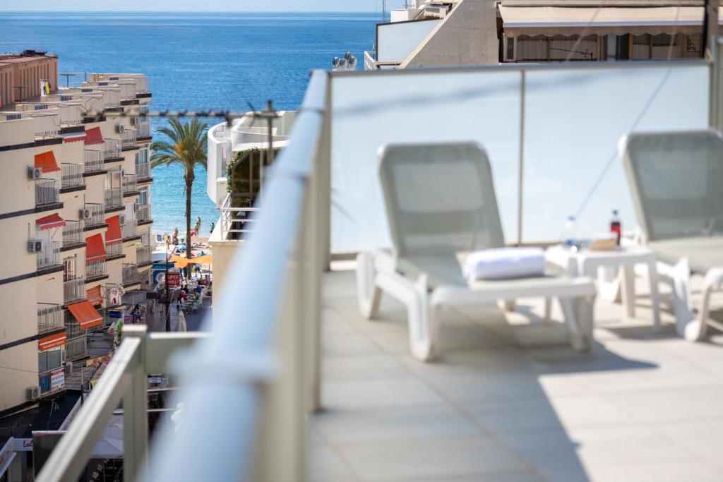 een balkon met stoelen en uitzicht op de oceaan bij 2Sleep - Estudios Benidorm in Benidorm