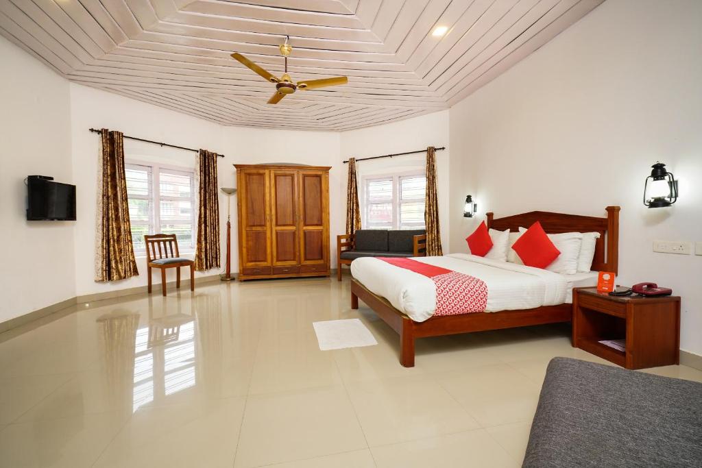a bedroom with a bed and a ceiling fan at OYO Hotel Merimaid in Munnar