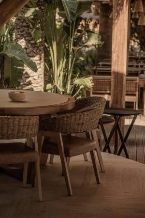 a table and chairs in a patio with a plant at Villa Victoria by La Scala Beach in Limenas
