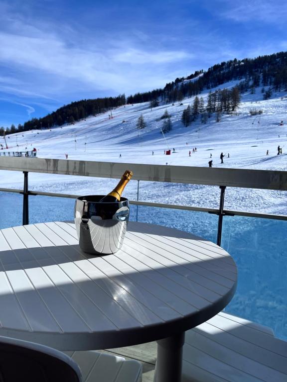 - une bouteille de champagne assise sur une table sur une piste de ski dans l'établissement Vip apartment on the ski slopes, à Montgenèvre