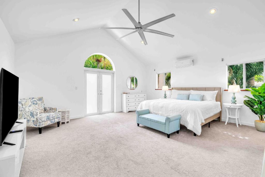 a white bedroom with a bed and a tv at Center Grove - Lush & Spacious & New - 3 Bedrooms in Miami
