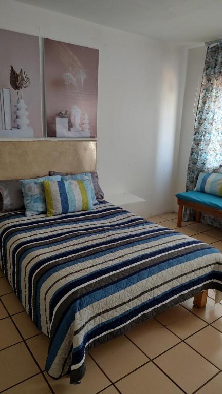 a bedroom with a bed and a blue bench at Habitación privada en casa de huespedes in Guadalajara