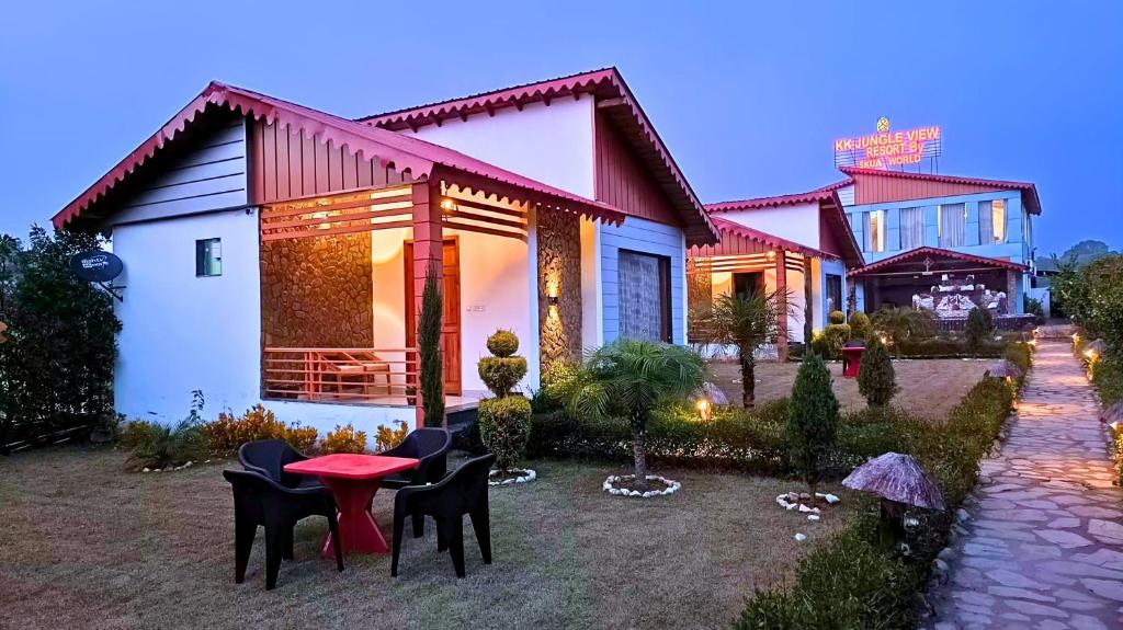 a house with chairs and a table in front of it at Asapian Resort & Spa - Formerly KK Jungle View Resort in Kota Bāgh