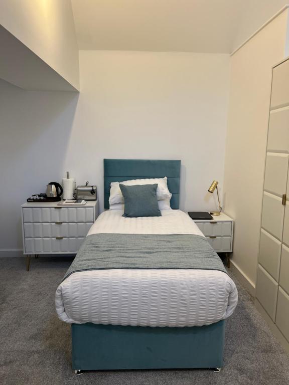 a bedroom with a large bed with a blue headboard at 12 Plants Yard -Modern Retreat in Worksop