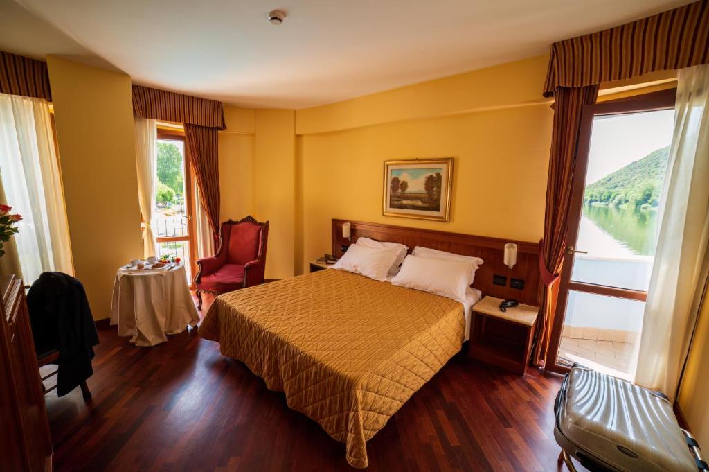 a hotel room with a bed and a large window at Hotel Miralago in Piediluco